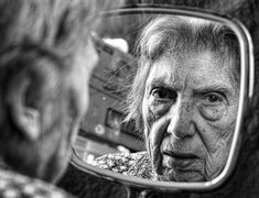 an old woman looking at herself in the mirror