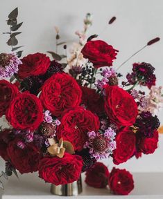 a vase filled with red flowers on top of a table