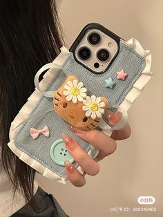 a woman holding an iphone case with a hello kitty phone cover on her hand,