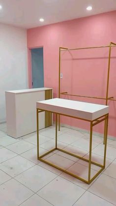 an empty room with pink walls and a gold frame on the floor in front of a white counter