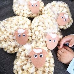 a child's hand is touching some popcorn in the shape of sheep