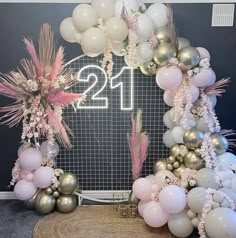 balloons and flowers are arranged around the number twenty sign