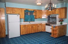 a kitchen with blue carpet and wooden cabinets