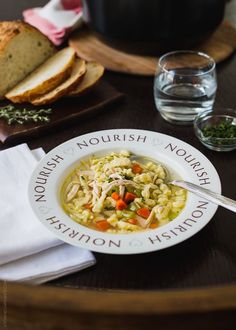 a bowl of soup on a table with bread and water