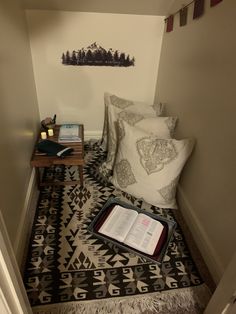 an open book sitting on top of a black and white floor next to a pillow