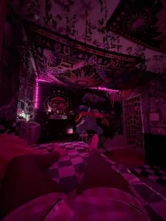 a bedroom with purple lighting and decorations on the ceiling is pictured in this image, it appears to be very dark