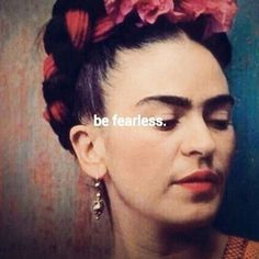 a woman with pink flowers in her hair and the words be fearless above her head