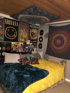 a bedroom with posters on the wall and a bed in front of it that has a yellow comforter