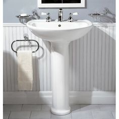 a white pedestal sink in a bathroom next to two mirrors and a towel rack on the wall