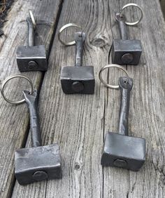 several pieces of metal sitting on top of a wooden table next to scissors and hooks