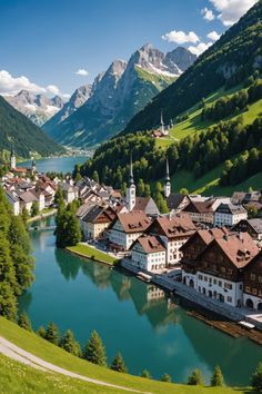 an aerial view of a small town in the middle of a lake surrounded by mountains