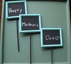 three small blackboards with writing on them are sitting in a green tray next to each other