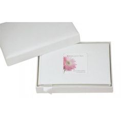 a white box with a single flower in it on a white surface, open to show the inside