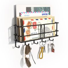 a wall mounted mail holder with keys and other items hanging from it's sides