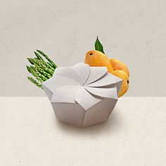 an origami bird with asparagus and oranges