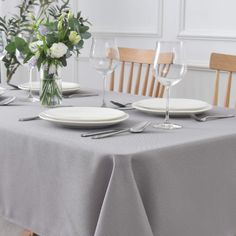 the table is set with white plates and silverware