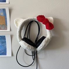 there is a crocheted cat headband hanging on the wall