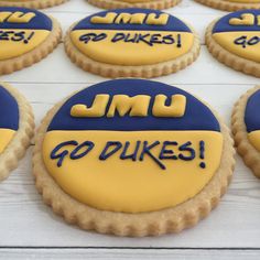 cookies decorated with blue and yellow frosting that say j m u go dukes