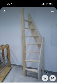 a wooden stair case next to a handrail in a room with white walls and flooring