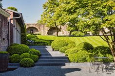 an outdoor area with steps, bushes and chairs