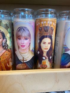 several different colored cups with pictures of women on them in a store shelf, one is holding a cross and the other has a crown