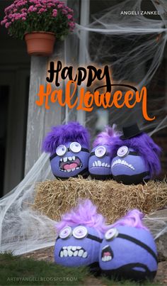 three purple stuffed animals sitting on hay with the words happy halloween written in orange above them