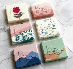 four soap bars with designs on them sitting on a marble counter top next to each other