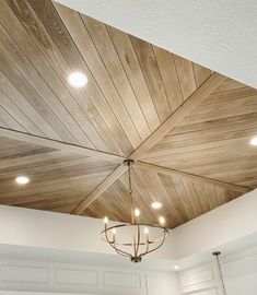 a ceiling with wooden planks and chandelier