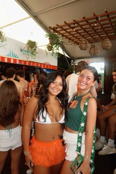 two young women standing next to each other in front of a crowd at a sports event