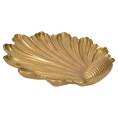 a gold leaf shaped dish on a white background