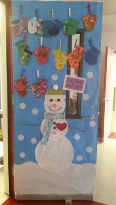 a bulletin board decorated with clothes and a snowman on the front door for christmas