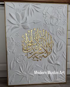 an intricately decorated card with arabic calligraphy on white paper and gold trimmings