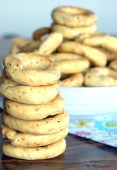 a stack of cookies sitting on top of a table next to a bowl of cookies