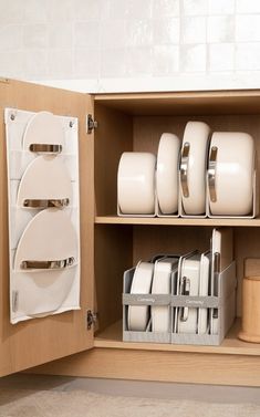 a cabinet filled with white dishes and plates