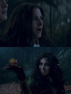 two women in the woods one is holding an apple and the other is looking at something