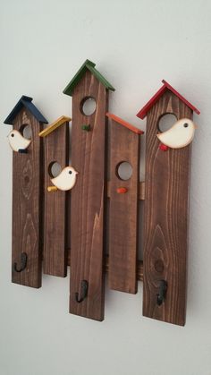 three wooden birdhouses with birds on them and holes in the wood that are attached to each other