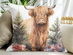 a pillow with a painting of a highland cow on it's side and presents in the background