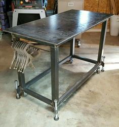 a metal table sitting on top of a floor next to a shelf filled with tools