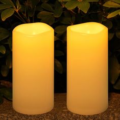 two white candles sitting next to each other