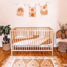 a baby crib in the corner of a room with plants and rugs on the floor