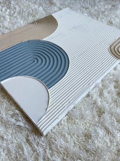 a white rug with blue and brown circles on top of it in the middle of a room