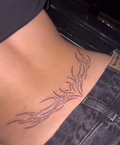 a woman's stomach with a tattoo design on the side and bottom part of her body