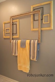 towels are hanging on the wall in front of two framed pictures and a towel rack