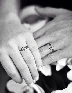 two people holding hands with tattoos on their fingers