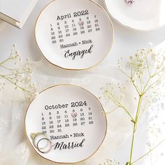 two personalized wedding plates with the date and year printed on them, sitting next to flowers