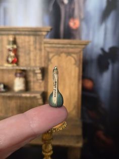 a tiny miniature figurine sitting on top of a table next to a cabinet