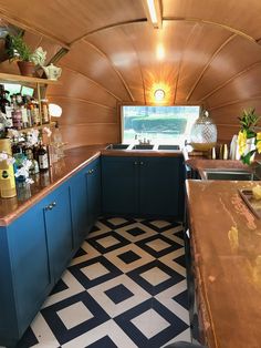 a kitchen with blue cabinets and counter tops in a small space that is decorated with black and white tiles