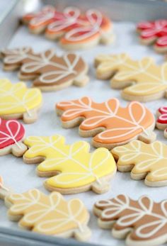 cookies decorated with leaves are on a baking sheet