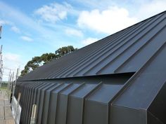 the roof of a building is made of metal sheets and has been folded down to form a triangular shape