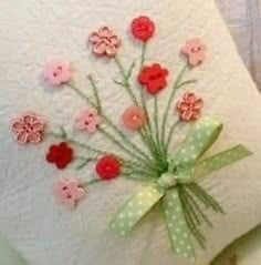 a white pillow with pink and red flowers on it